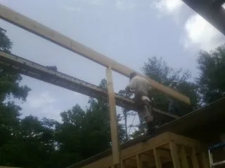 Carpenter setting a ridge beam over a new addition frame — Ice Dam Removal by Roofing Brothers in Sproul