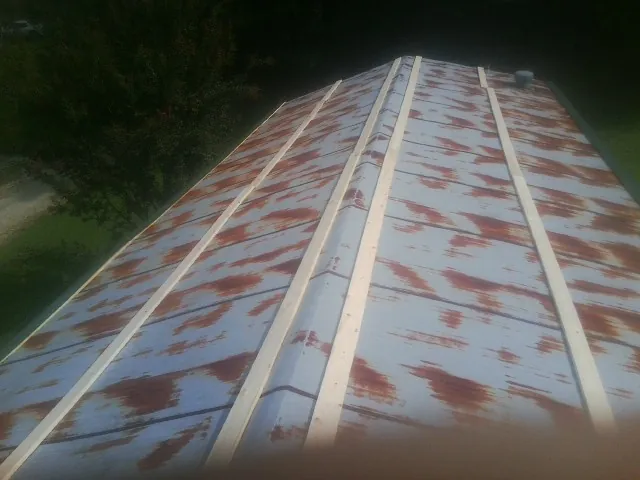 Rusted metal roof panels with new wood purlins before replacement — Storm Damage Roof Repair in Sproul by Roofing Brothers