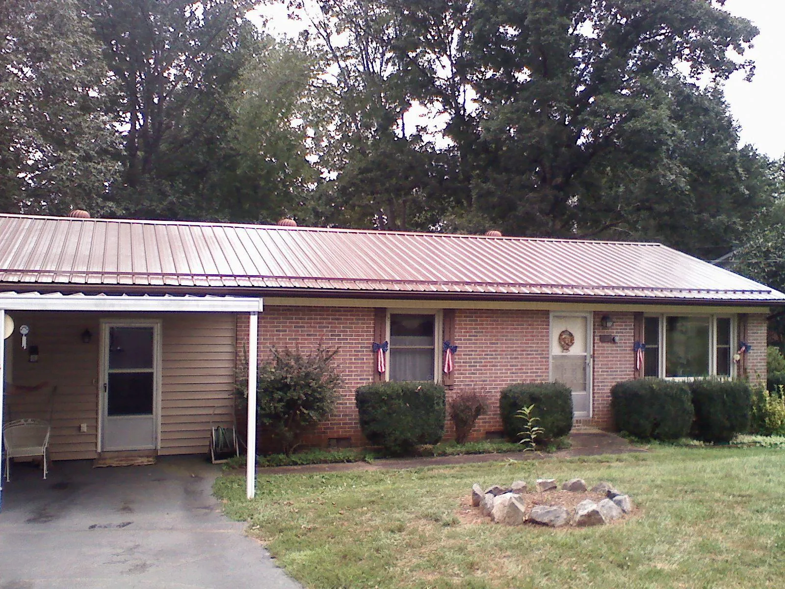 Bronze metal roof and carport on a brick ranch home — Roof Repair work by our crew in Sproul